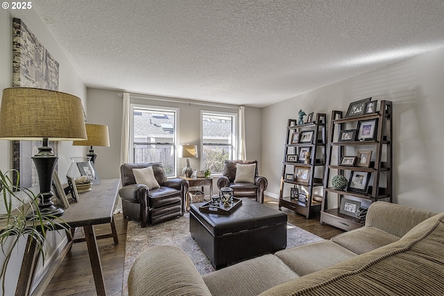 living room with a textured ceiling, baseboards, and wood finished floors