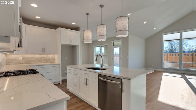 kitchen featuring pendant lighting, a center island with sink, sink, vaulted ceiling, and stainless steel appliances