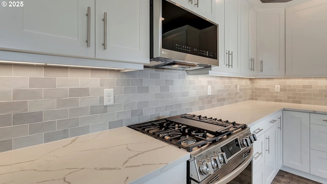 kitchen featuring tasteful backsplash, white cabinetry, and stainless steel appliances