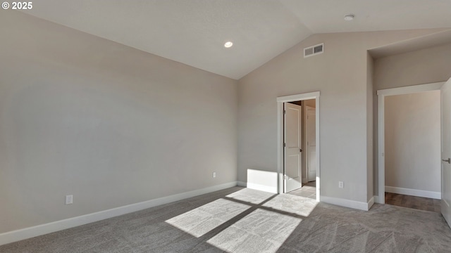 unfurnished bedroom featuring light colored carpet and lofted ceiling