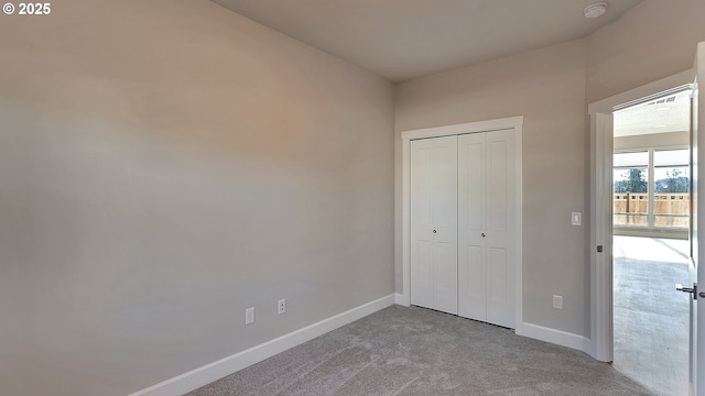 unfurnished bedroom featuring a closet and light colored carpet