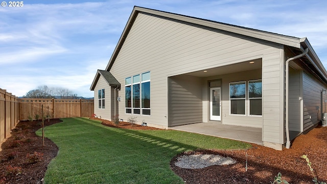 back of house featuring a lawn and a patio