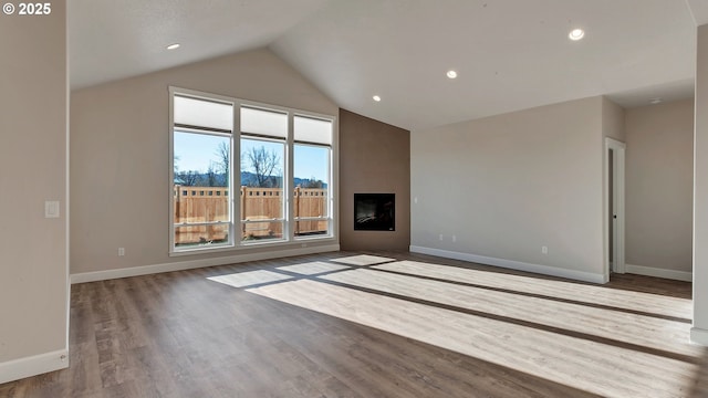 unfurnished living room featuring hardwood / wood-style floors, a healthy amount of sunlight, and vaulted ceiling