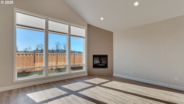 unfurnished living room with wood-type flooring, a fireplace, and vaulted ceiling