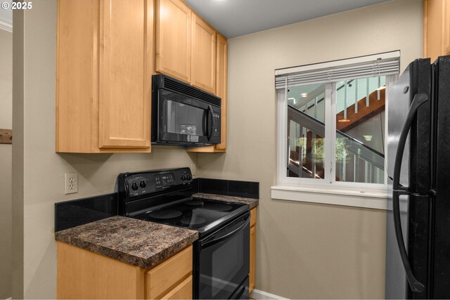 5050 S Landing Dr Unit 202, Portland, OR 97239 - kitchen with black appliances, dark countertops, light brown cabinets, and baseboards