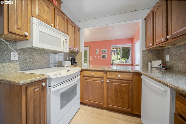 16952 SE Dunhill Loop, Damascus, OR 97089 - kitchen with white appliances, brown cabinetry, and light wood-type flooring