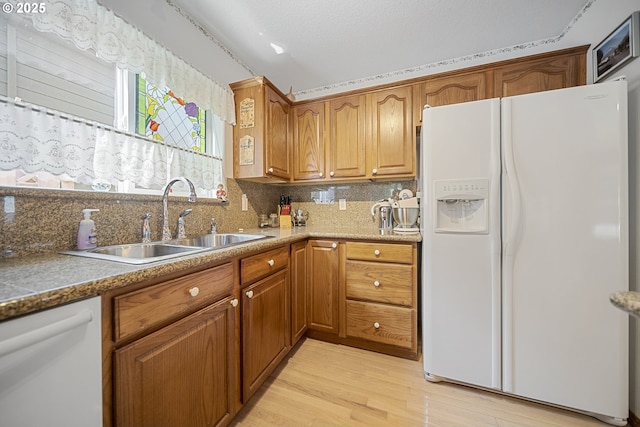 16952 SE Dunhill Loop, Damascus, OR 97089 - kitchen with white appliances, decorative backsplash, light wood-type flooring, and brown cabinetry