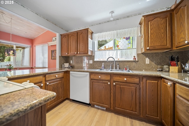 16952 SE Dunhill Loop, Damascus, OR 97089 - kitchen featuring white dishwasher, vaulted ceiling, brown cabinetry, and light wood-type flooring
