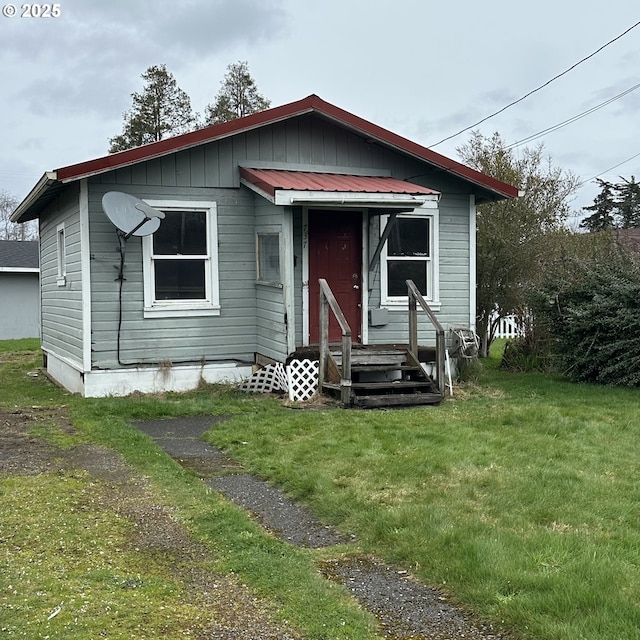 bungalow-style house with a front lawn and metal roof