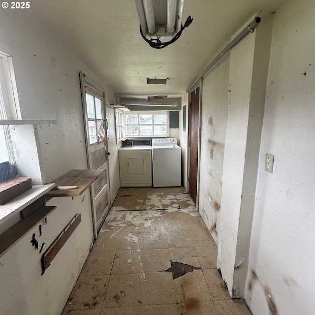 laundry room featuring laundry area, separate washer and dryer, and a textured ceiling