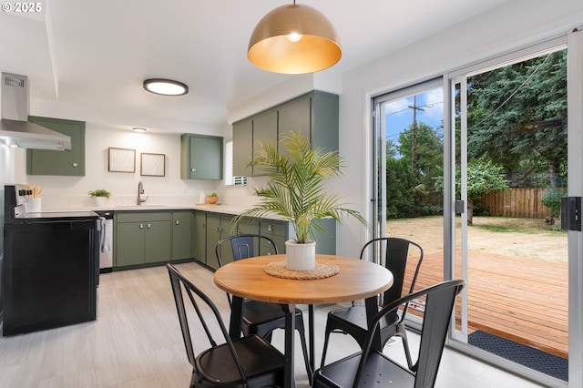 165 NE 167th Pl, Portland, OR 97230 - kitchen featuring green cabinetry, wall chimney exhaust hood, light countertops, and range with electric cooktop