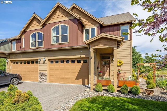 view of front of property featuring board and batten siding, an attached garage, and decorative driveway