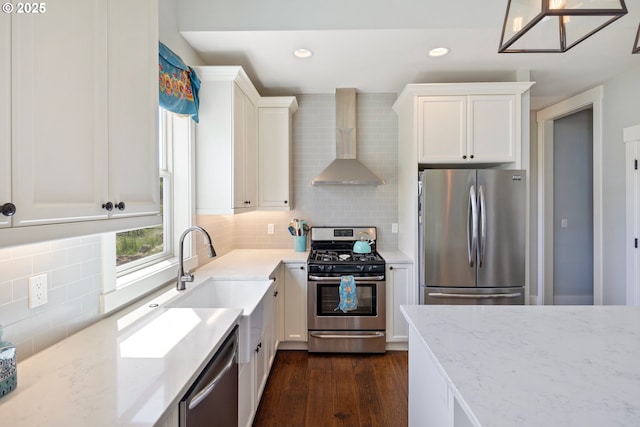 kitchen featuring stainless steel appliances, wall chimney range hood, tasteful backsplash, white cabinets, and recessed lighting