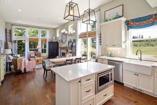 kitchen featuring stainless steel appliances, a chandelier, dark wood-style flooring, recessed lighting, and open floor plan