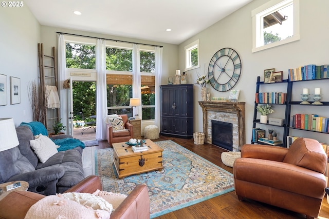 living area with wood finished floors, a fireplace, and recessed lighting