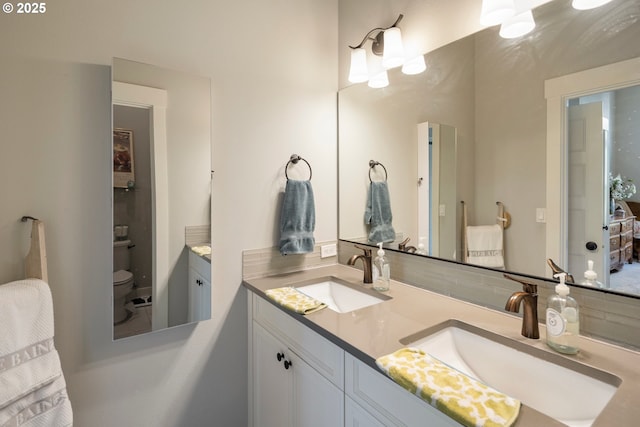 bathroom featuring double vanity and toilet