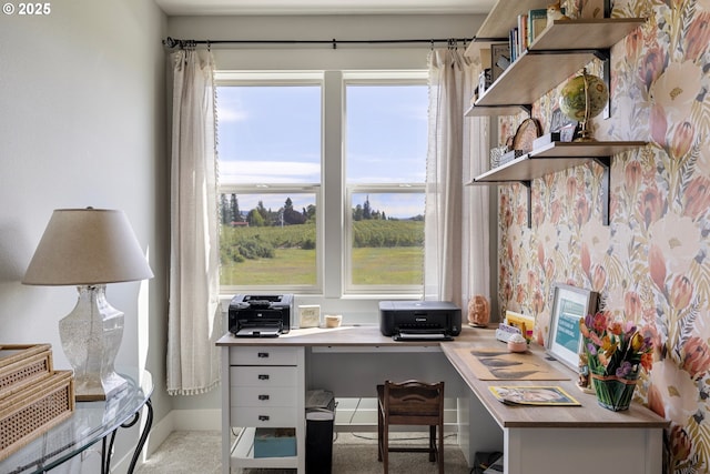 carpeted office space featuring baseboards and built in desk