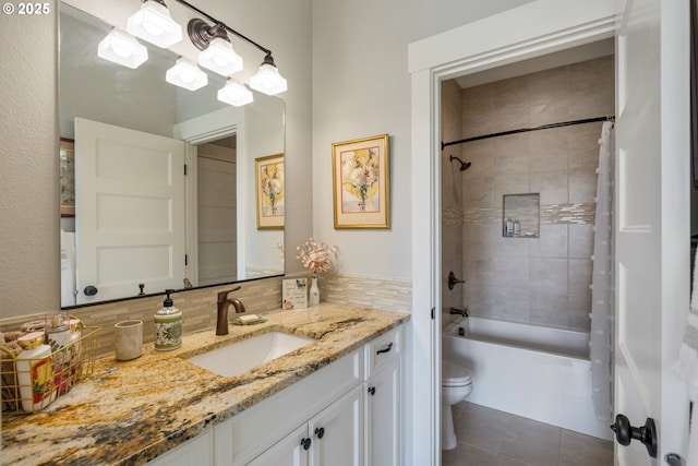 full bathroom featuring toilet, tile patterned flooring, vanity, shower / tub combination, and decorative backsplash