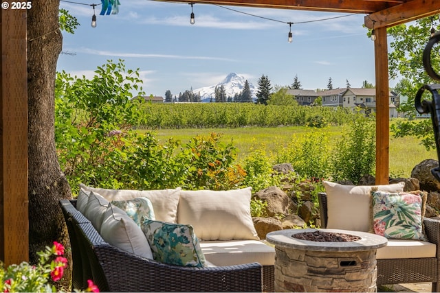 view of patio / terrace with an outdoor living space with a fire pit and a mountain view