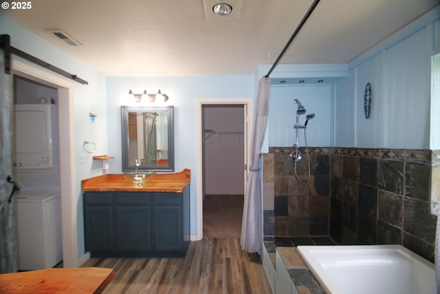 1974 N Laurelwood St, Canby, OR 97013 - full bathroom featuring stacked washer and clothes dryer, a tile shower, wood finished floors, vanity, and a spacious closet