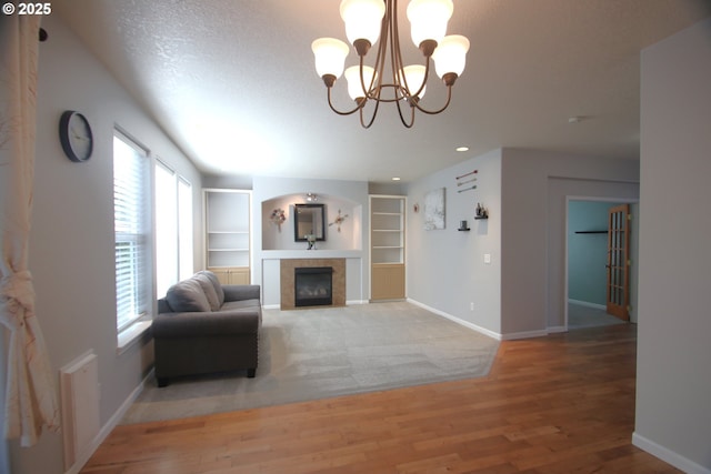 1974 N Laurelwood St, Canby, OR 97013 - living area with built in shelves, a fireplace, a chandelier, light wood finished floors, and recessed lighting