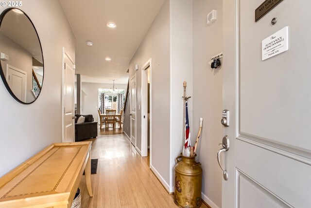 hallway featuring a chandelier and light wood-type flooring