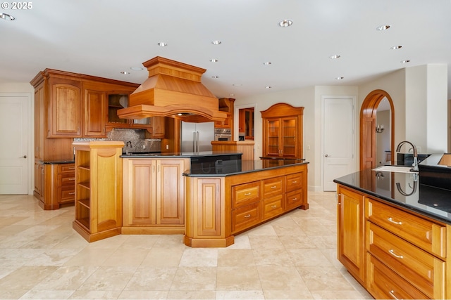 kitchen featuring a center island, open shelves, arched walkways, appliances with stainless steel finishes, and island range hood