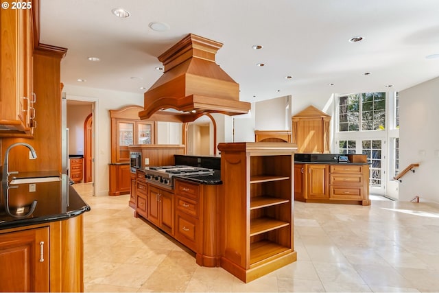 kitchen featuring a center island, open shelves, a sink, stainless steel gas stovetop, and island range hood