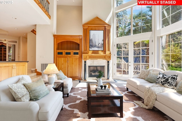 living area with recessed lighting, a towering ceiling, and a premium fireplace