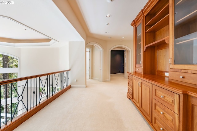 hallway with arched walkways, light colored carpet, baseboards, and recessed lighting
