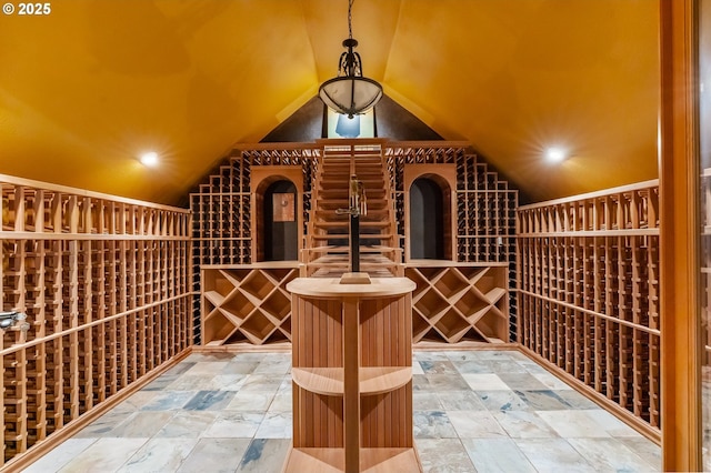 wine cellar with recessed lighting, stone finish floor, and lofted ceiling
