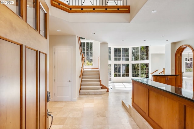foyer entrance with light tile patterned floors, recessed lighting, a high ceiling, and stairway