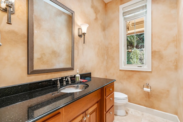 bathroom with tile patterned floors, vanity, baseboards, and toilet