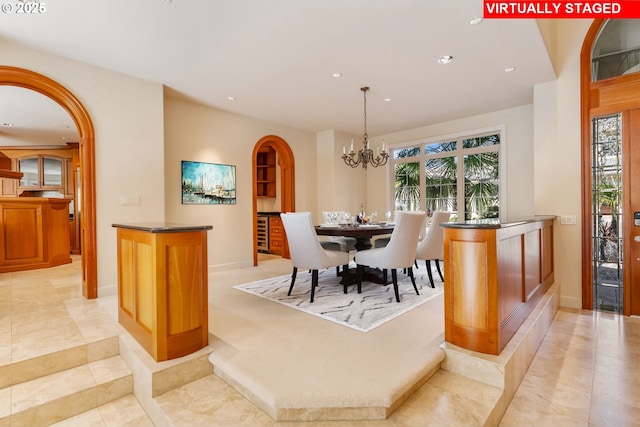 dining area with light tile patterned floors, arched walkways, recessed lighting, a notable chandelier, and baseboards