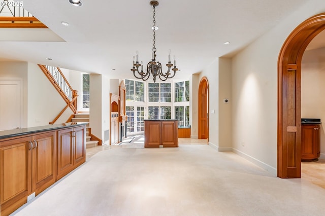 unfurnished dining area with arched walkways, light colored carpet, recessed lighting, a notable chandelier, and baseboards