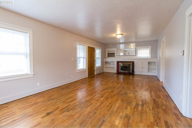 1522 N Rosa Parks Way, Portland, OR 97217 - unfurnished living room with baseboards, a brick fireplace, wood finished floors, and a textured ceiling