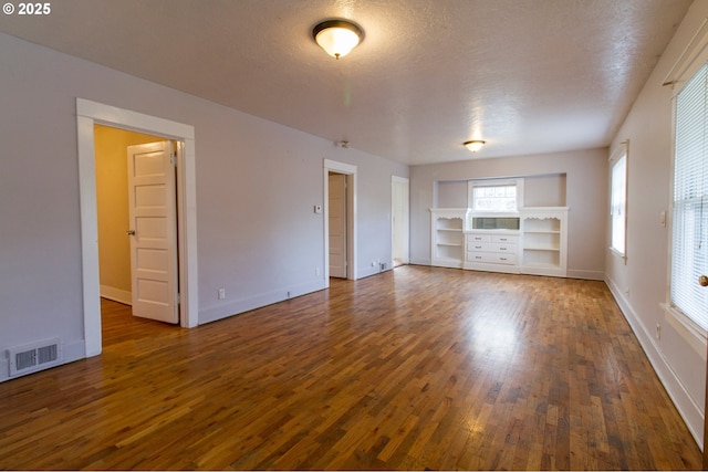 1522 N Rosa Parks Way, Portland, OR 97217 - spare room with wood finished floors, visible vents, baseboards, a textured ceiling, and built in shelves