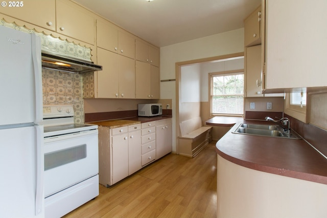 1522 N Rosa Parks Way, Portland, OR 97217 - kitchen featuring a sink, white appliances, light wood finished floors, cream cabinetry, and under cabinet range hood