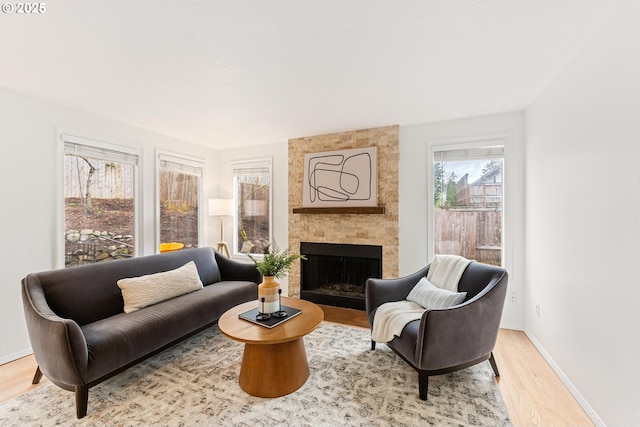 living room featuring baseboards, wood finished floors, and a fireplace