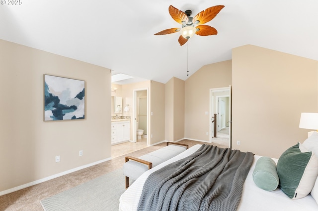 bedroom featuring baseboards, ceiling fan, light colored carpet, lofted ceiling, and ensuite bathroom