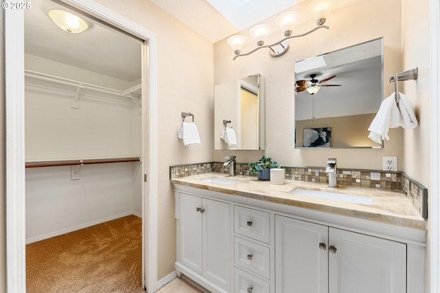 bathroom featuring double vanity, a ceiling fan, baseboards, and a sink