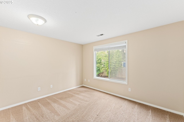 carpeted spare room with baseboards and visible vents