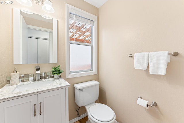 bathroom with vanity, toilet, and baseboards