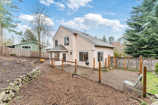 rear view of house with a patio area and a fenced backyard