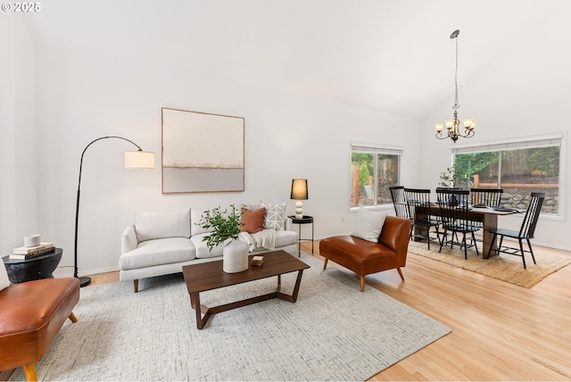 living room with baseboards, high vaulted ceiling, an inviting chandelier, and wood finished floors