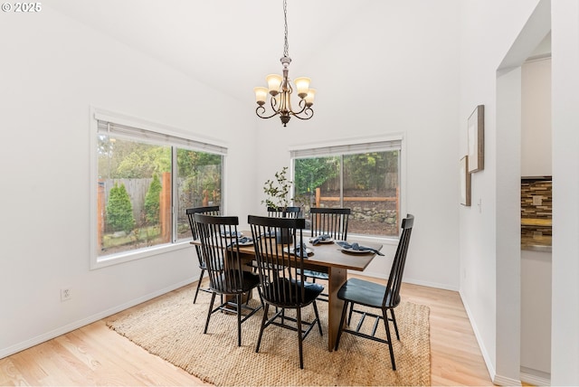 dining room with a chandelier, baseboards, light wood-style floors, and a wealth of natural light