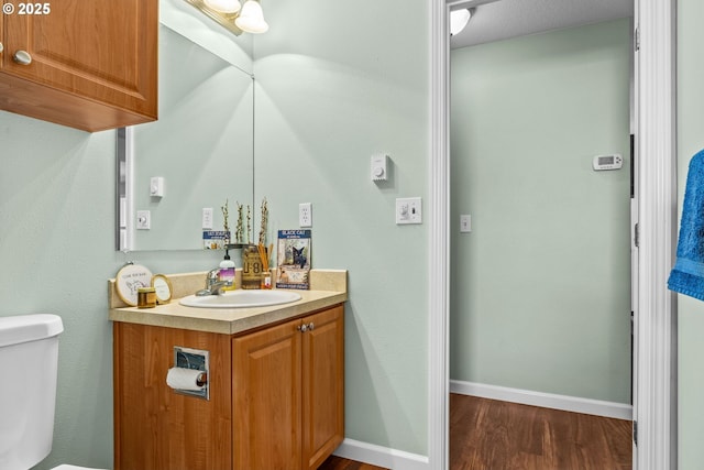 34637 E Knox Butte Rd, Albany, OR 97322 - half bathroom with wood finished floors, vanity, toilet, and baseboards