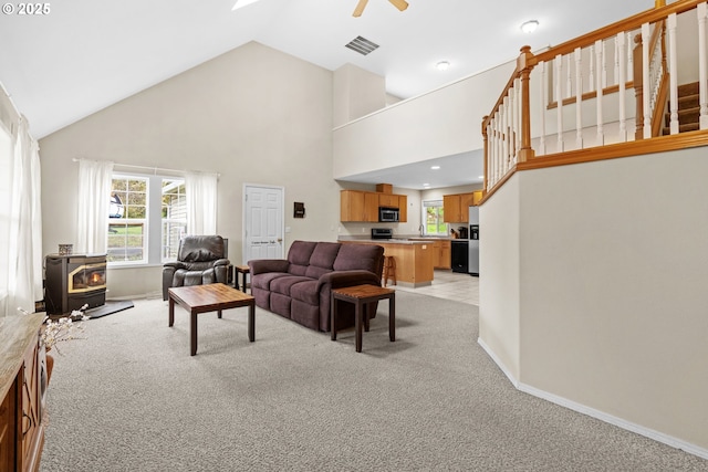 40510 NE 261st Ct, Amboy, WA 98601 - living area with a wood stove, visible vents, ceiling fan, high vaulted ceiling, and light colored carpet
