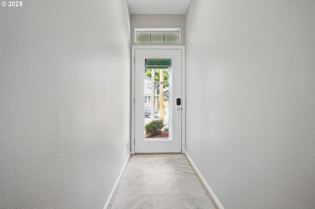 entryway featuring baseboards and a textured wall