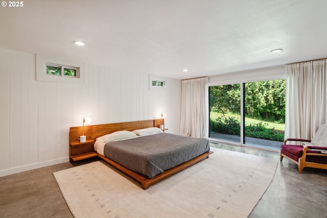 bedroom featuring finished concrete floors, recessed lighting, and access to exterior
